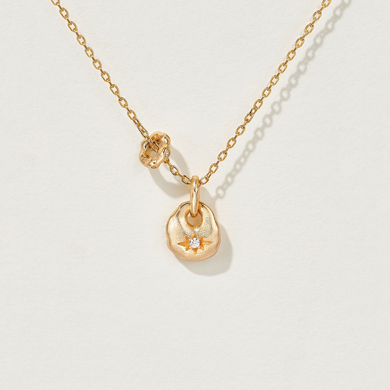 lucky purse n✨ a blessing carried in a tiny purse. the lucky purse necklace draws inspiration from ancient embroidered sachets—symbols of peace, joy, and prosperity. its petite size magnifies its meaning: a vessel that condenses blessings into a precious charm for daily wear. handcrafted with a softly rounded silhouette and a vintage gold finish, the purse motif glows with warmth. at its center lies a delicate starburst engraving, inlaid with a sparkling cubic zirconia that shines like a hidden treasure. every glance reveals its dual essence—ornamental beauty and symbolic protection. whether worn close to the heart or given as a meaningful gift, this necklace brings quiet elegance and timeless good fortune into everyday life. design details miniature purse motif (9mm): inspired by traditional silk sachets, reimagined as a refined jewelry keepsake. starburst engraving: a classic six point carving that enhances the vintage charm. cubic zirconia accent: a luminous centerpiece symbolizing prosperity and joy. dual charms: the purse pendant pairs with a rotating ring detail, balancing “hold & release” in harmony. materials metal: 925 sterling silver with 18k gold plating stone: high grade cubic zirconia (synthetic) finish: hand polished with antique texture dimensions pendant size: 0.37 in x 0.35 in (9.6 mm x 8.8 mm) chain length: 15.7 in (400 mm) + 2.0 in (50 mm) extender weight: approx. 3.2 g styling tips wear as a subtle daily talisman to invite blessings and peace. perfect for layering with delicate chains for a modern, effortless look. a thoughtful gift for birthdays, milestones, or festive occasions—symbolizing good fortune and heartfelt wishes. why you’ll love it 🌟 a timeless symbol of blessings and prosperity 💫 petite yet powerful—small details with deep meaning 🎁 perfect as both a personal keepsake and a meaningful gift ✨ vintage finish and starburst engraving add artisanal charmecklace